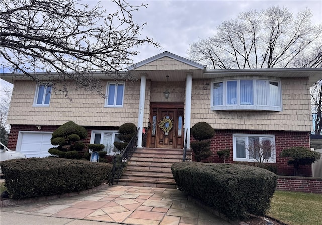 split foyer home featuring an attached garage and brick siding