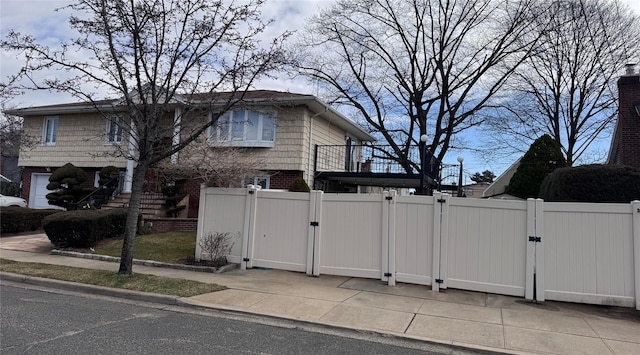 view of home's exterior with a gate, fence, and brick siding