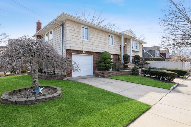 bi-level home with brick siding, a front lawn, fence, a chimney, and a garage