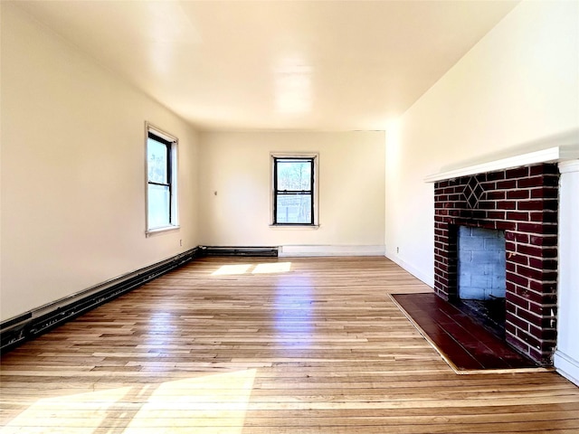 unfurnished living room featuring a brick fireplace, wood-type flooring, and baseboards