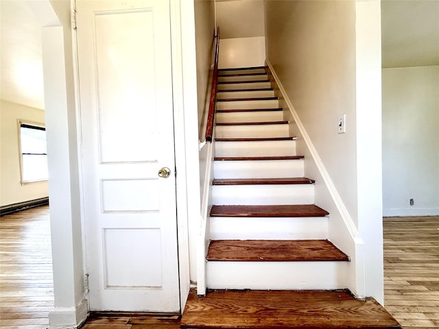 stairway with baseboards and wood finished floors