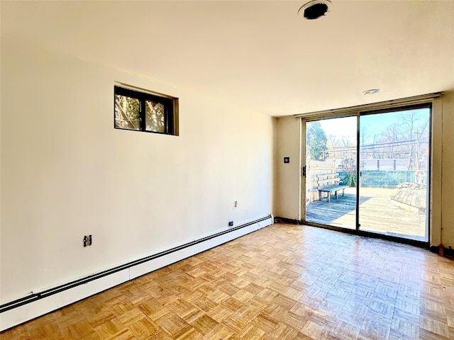 empty room featuring a baseboard radiator and floor to ceiling windows