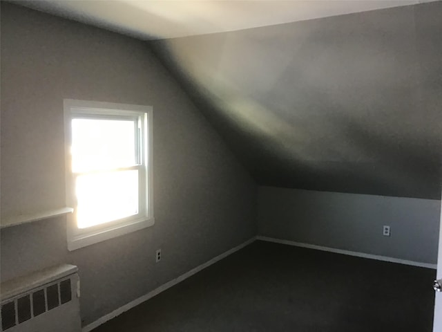 additional living space featuring lofted ceiling, radiator heating unit, and baseboards