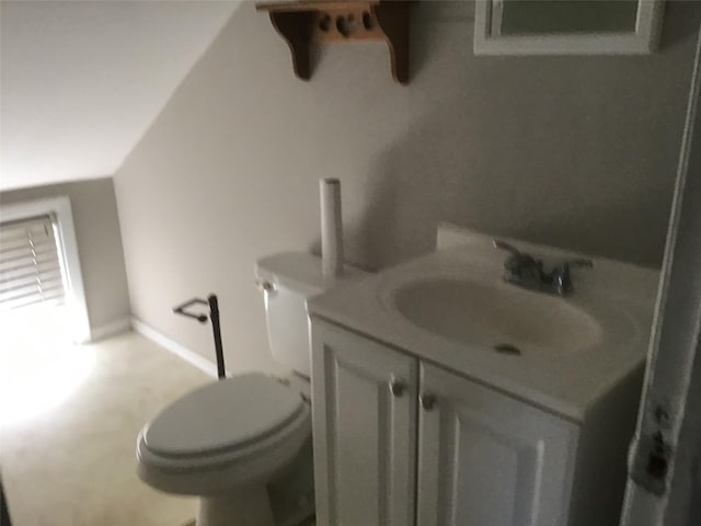 bathroom featuring baseboards, vanity, and toilet