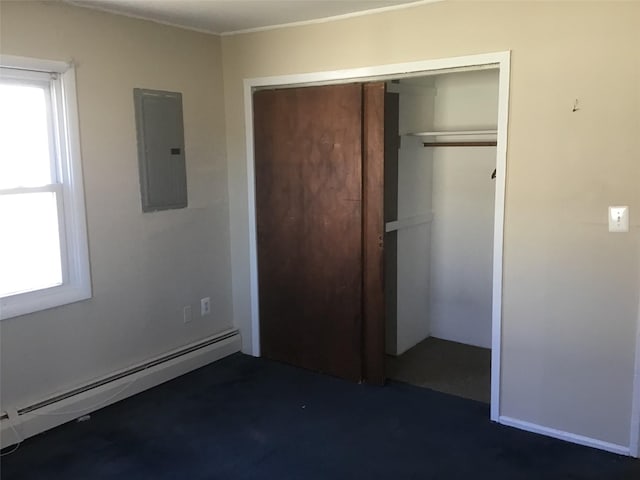 unfurnished bedroom featuring baseboard heating, a closet, and electric panel