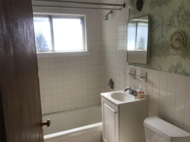 full bath with tile walls, bathtub / shower combination, toilet, vanity, and wallpapered walls