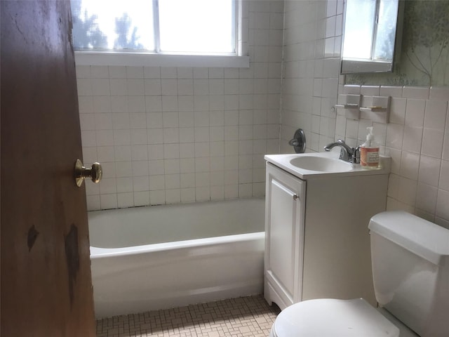 full bathroom with toilet, tile patterned floors, a bathtub, vanity, and tile walls