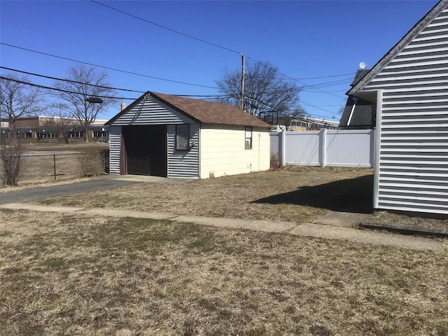 exterior space with an outbuilding, fence private yard, and a garage