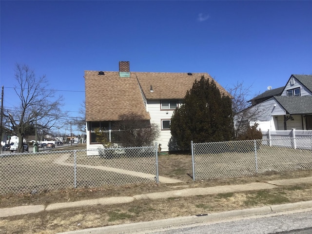 view of property exterior featuring a fenced front yard, a chimney, and a shingled roof