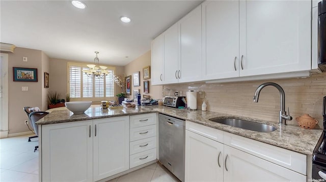 kitchen featuring light tile patterned floors, stainless steel dishwasher, white cabinetry, a sink, and a peninsula