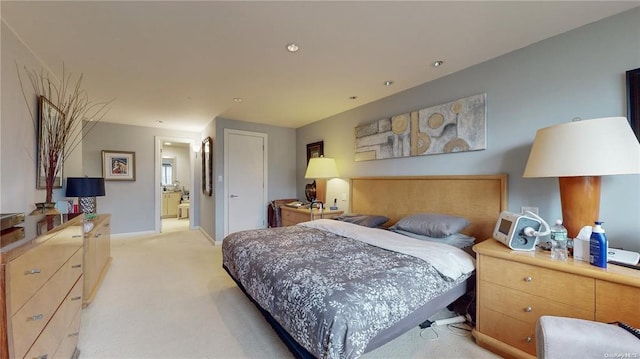 bedroom featuring light carpet, ensuite bath, and baseboards