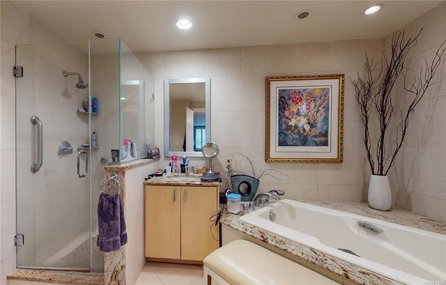 full bath with tile walls, vanity, a shower stall, a bath, and tile patterned floors