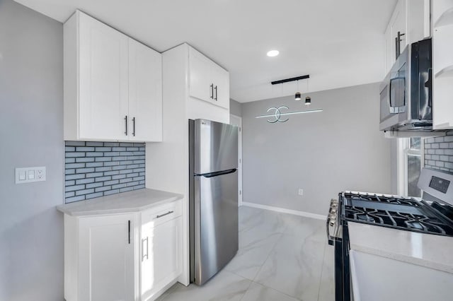 kitchen featuring tasteful backsplash, marble finish floor, appliances with stainless steel finishes, and white cabinetry