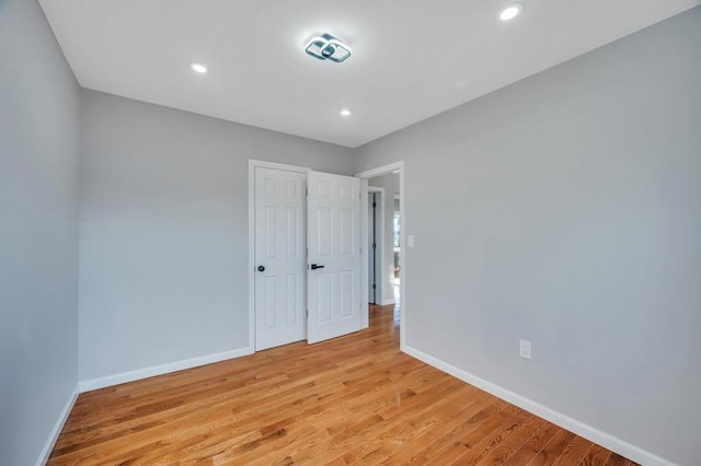 unfurnished bedroom featuring recessed lighting, light wood-type flooring, and baseboards