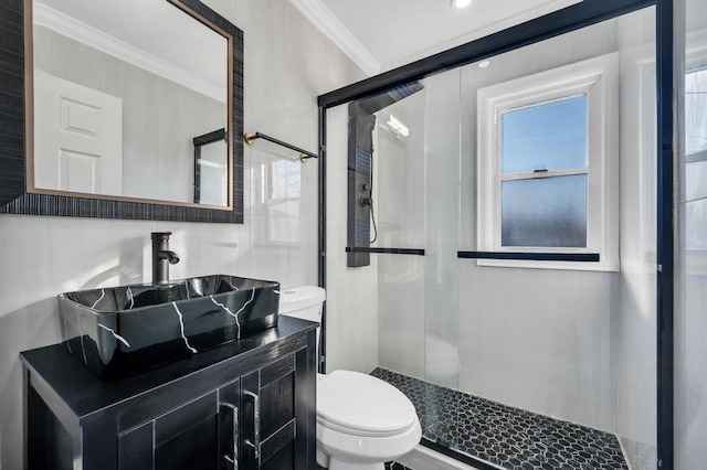 bathroom with a stall shower, toilet, crown molding, and vanity