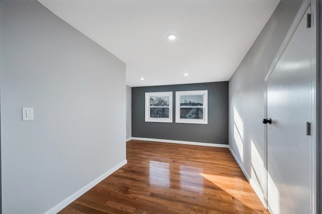 spare room featuring recessed lighting, wood finished floors, and baseboards