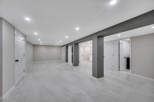 finished below grade area with recessed lighting, marble finish floor, and baseboards