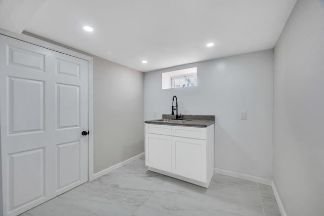 bar with a sink, baseboards, marble finish floor, and recessed lighting