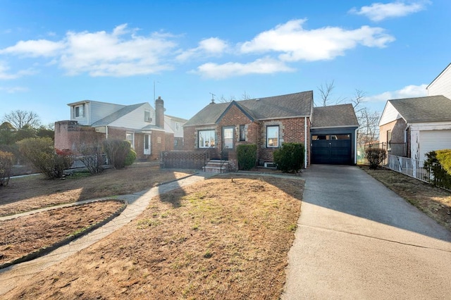 view of front of property with brick siding, an attached garage, driveway, and fence