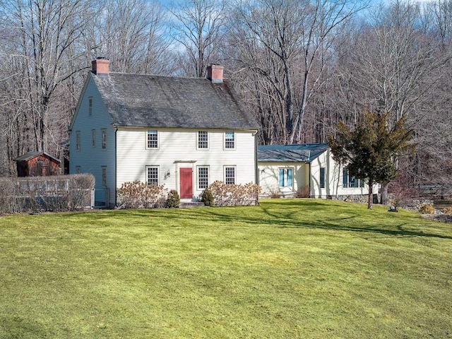 view of front facade featuring a chimney and a front lawn