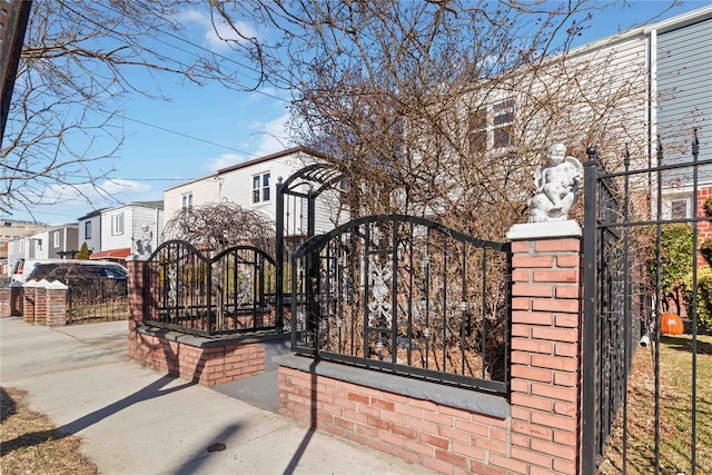 view of gate featuring fence and a residential view