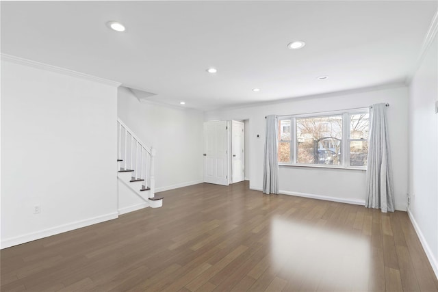 unfurnished living room featuring baseboards, wood finished floors, stairs, and crown molding