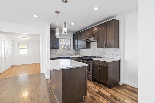 kitchen with under cabinet range hood, tasteful backsplash, dark brown cabinetry, and stainless steel range with gas stovetop