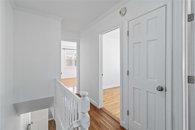 hall featuring an upstairs landing, dark wood-style floors, baseboards, and ornamental molding