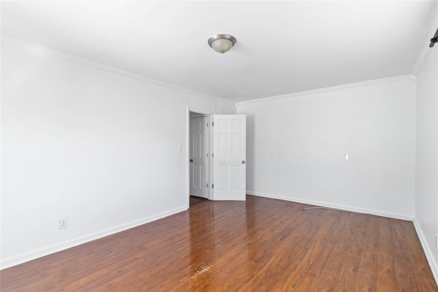 unfurnished room featuring crown molding, baseboards, and wood finished floors