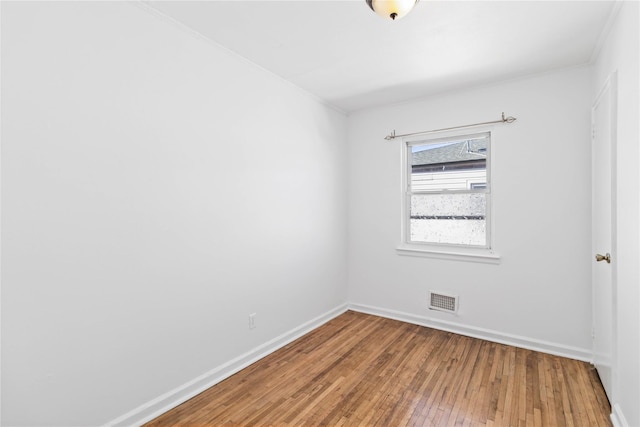 unfurnished room featuring baseboards, visible vents, and light wood finished floors