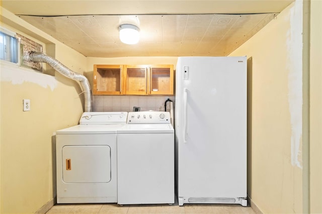 washroom featuring baseboards, cabinet space, and washing machine and clothes dryer