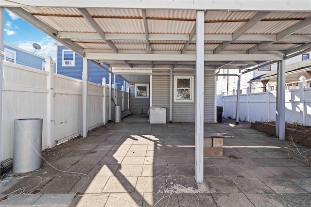 view of patio / terrace with an attached carport and fence