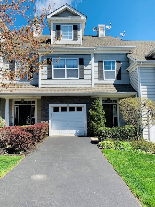 view of front of house featuring aphalt driveway, a garage, and roof with shingles