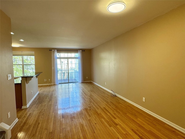 unfurnished room featuring baseboards and hardwood / wood-style floors