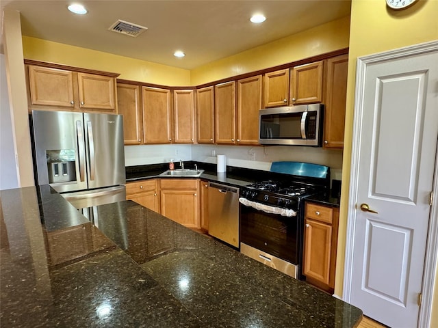 kitchen featuring visible vents, brown cabinets, a sink, recessed lighting, and stainless steel appliances