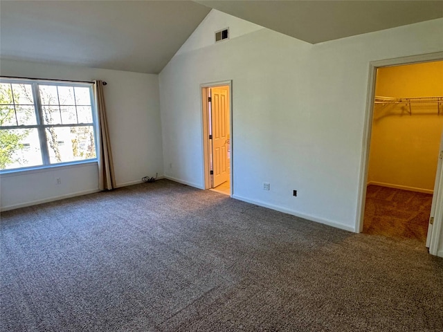 unfurnished bedroom with visible vents, lofted ceiling, carpet floors, baseboards, and a spacious closet