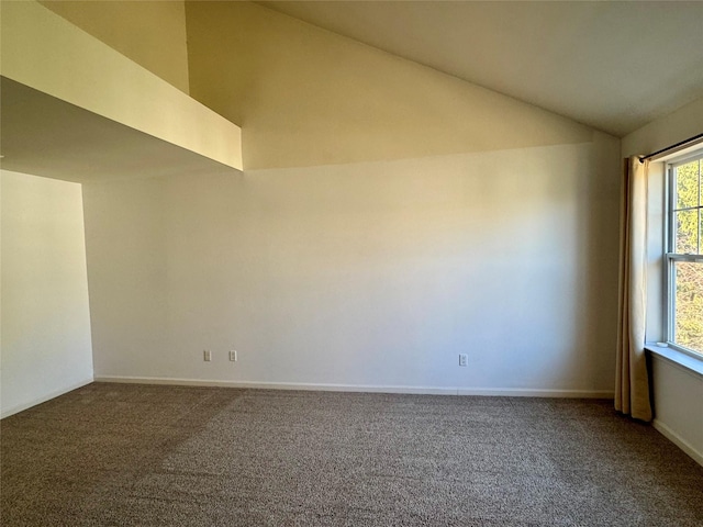 carpeted empty room featuring baseboards and lofted ceiling