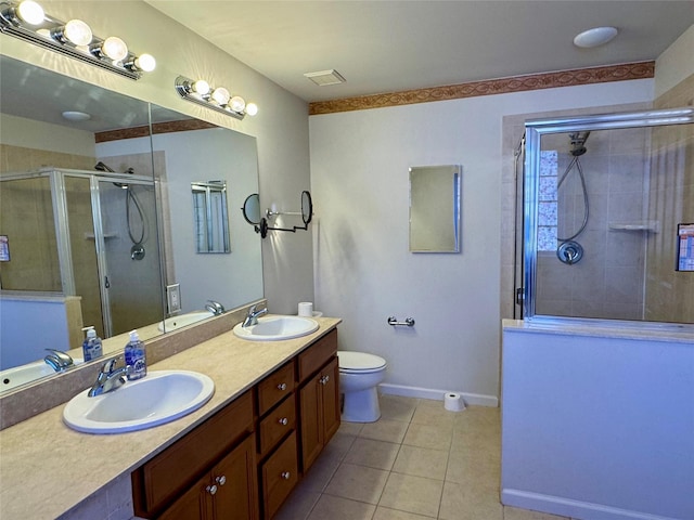 bathroom featuring tile patterned flooring, a stall shower, and a sink