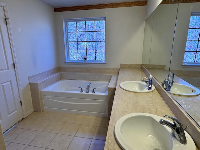 bathroom with tile patterned flooring, a bath, and a sink