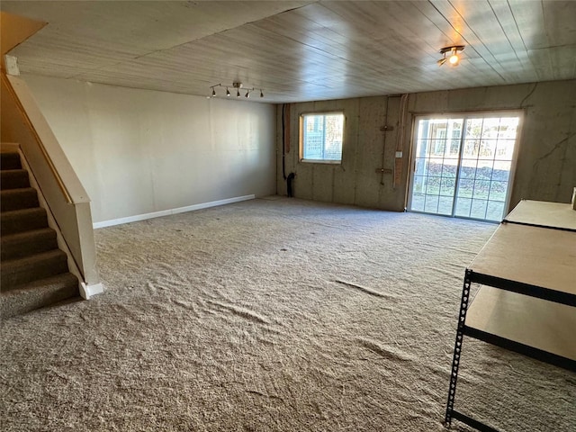 unfurnished living room featuring stairs and carpet floors