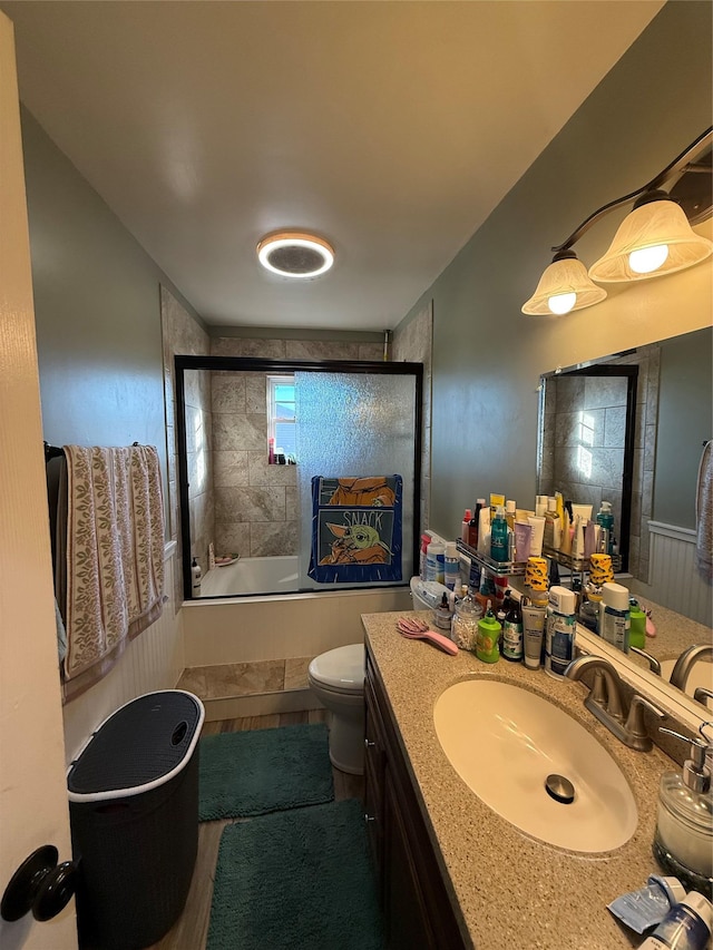 full bathroom featuring tiled shower / bath combo, vanity, and toilet