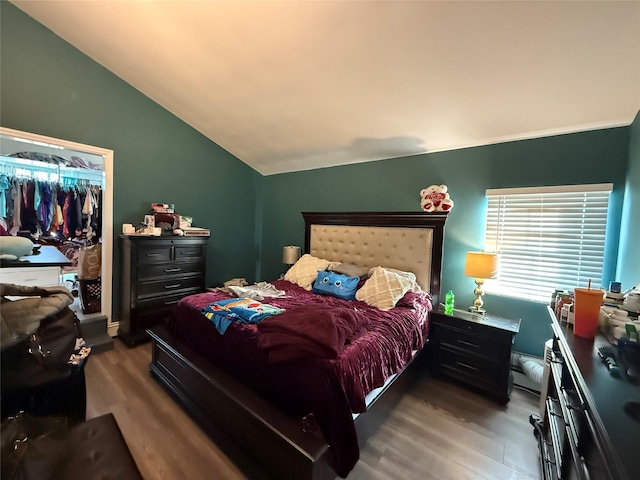 bedroom with lofted ceiling and wood finished floors