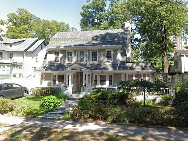 view of front of home with covered porch and a chimney