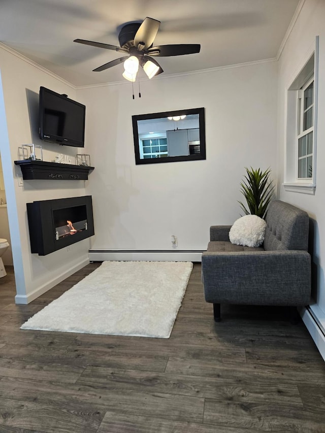 living area featuring dark wood-type flooring, baseboard heating, a warm lit fireplace, and ornamental molding