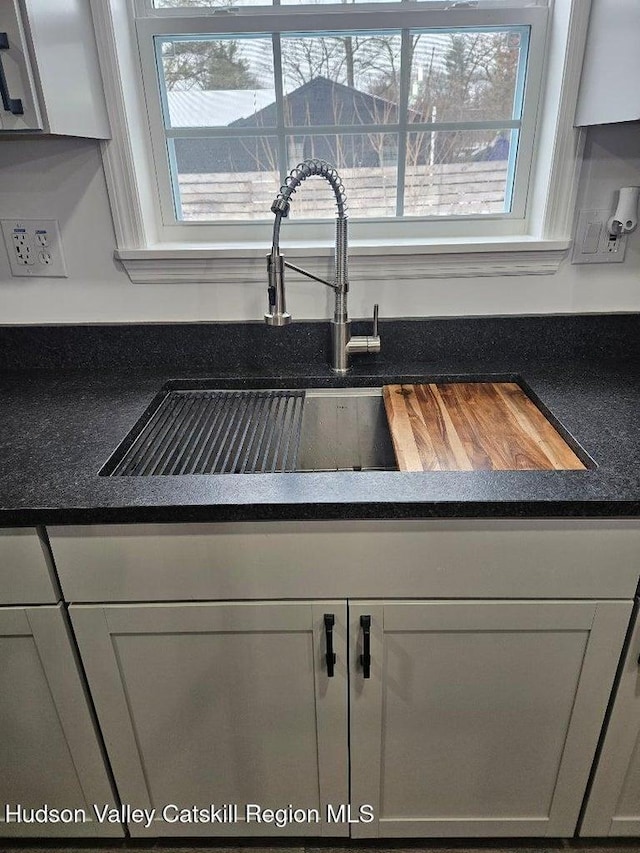 details with dark countertops and a sink