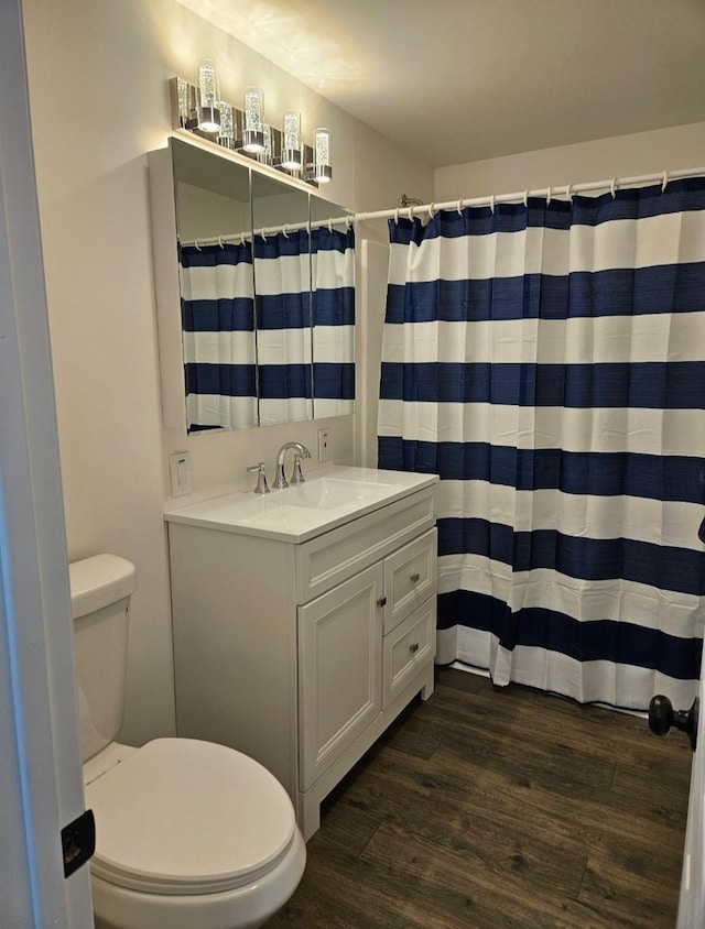 full bath with curtained shower, toilet, vanity, and wood finished floors