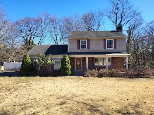 traditional home featuring a chimney and brick siding