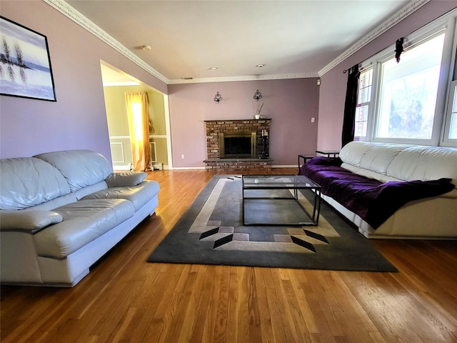 living room with baseboards, a brick fireplace, wood finished floors, and crown molding