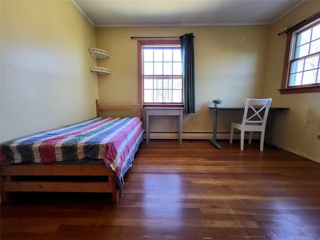 bedroom with ornamental molding and wood finished floors