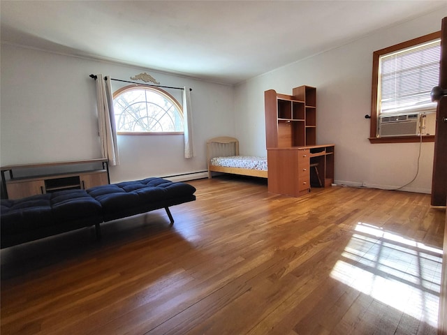 bedroom with cooling unit, a baseboard radiator, baseboards, and hardwood / wood-style flooring